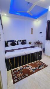 a bedroom with a large bed with a blue ceiling at Hotel Mannat - Near Thyagaraj Sports Complex in New Delhi