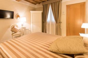 a bedroom with a large bed with a chair and a window at Residenza Marchesi Pontenani in Florence