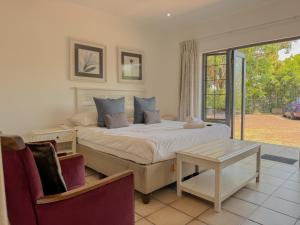 a bedroom with a large bed and a patio at Amoris Guesthouse on Orion in Pretoria