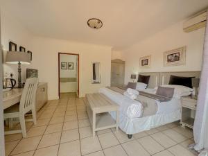a bedroom with a bed and a desk and a clock at Amoris Guesthouse on Orion in Pretoria +2 photos