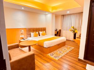 a hotel room with a bed and a table at Yeasel Continental Gangtok in Gangtok
