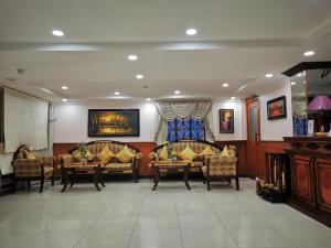 Una sala de estar con sofás y sillas en una habitación. en Jun Yue Hotel, en Phnom Penh