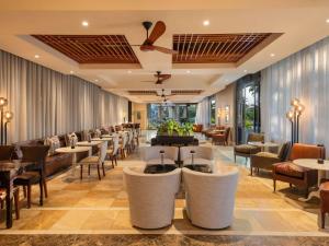 a restaurant with a row of tables and chairs at Mövenpick Hotel Windhoek in Windhoek