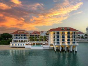 a hotel on the water with a sunset at Sofitel Legend Casco Viejo, Panama City in Panama City