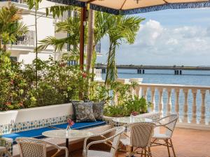 a patio with tables and chairs and a view of the ocean at Sofitel Legend Casco Viejo, Panama City in Panama City