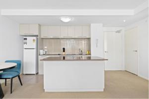 贝尔康嫩Modern 1bed Apartment with Resort-Style Amenities的厨房配有白色橱柜和白色冰箱