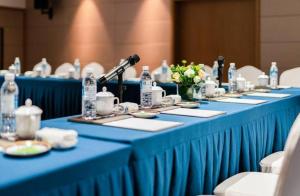 długi niebieski stół z białymi krzesłami i butelkami w obiekcie Hengding Century Hotel Chengdu w mieście Chengdu