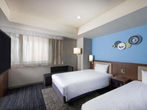 ein Hotelzimmer mit zwei Betten und einem Fernseher in der Unterkunft ibis Styles Kyoto Shijo in Kyoto + 105 Fotos