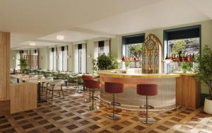 a restaurant with a bar and tables and chairs at The Derby London City, Curio Collection By Hilton in London +5 photos