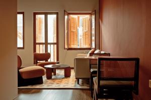 a living room with a table and two windows at Habyt Chinatown in Singapore