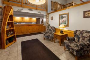 a living room with two chairs and a table at Shell Lake Lodge, a Travelodge by Wyndham in Shell Lake