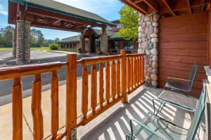 a porch with a wooden fence and a chair at Shell Lake Lodge, a Travelodge by Wyndham in Shell Lake