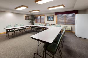 a conference room with tables and chairs and a refrigerator at Shell Lake Lodge, a Travelodge by Wyndham in Shell Lake +89 photos