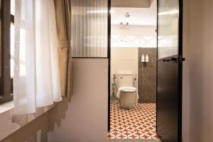 a bathroom with a toilet and a tile floor at Habyt Chinatown in Singapore