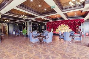 秦皇島市にあるJunyu Grand Hotel Qinhuangdaoの椅子とテーブルとステージ付きの宴会場