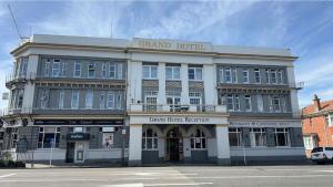 un gran hotel en la esquina de una calle en The Grand hotel whanganui under new management, en Whanganui