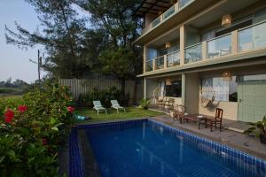 una casa con piscina delante de una casa en Artist Beach House, en Morjim