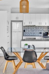 a kitchen with a glass table and two chairs at The Palms Apartments in Merimbula