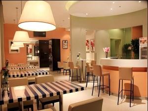 a restaurant with chairs and tables and a bar at Jinjiang Inn Dalian Development Zone Jinma Road Light Railway Station in Jinzhou