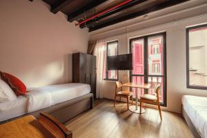 a hotel room with a bed and a table and chairs at Habyt Chinatown in Singapore