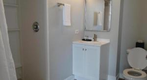 a white bathroom with a toilet and a mirror at The Chicago Hotel Collection Millennium Park in Chicago