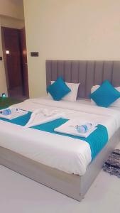 a large bed with blue pillows on it at HOTEL SUN town in Ahmedabad