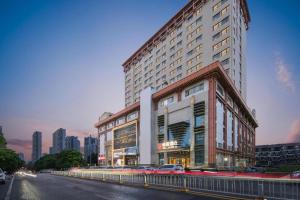 a large building with cars parked in front of it at Echeng Hotel Wuhan Optics Valley Square Yangjiawan Metro Station in Wuhan