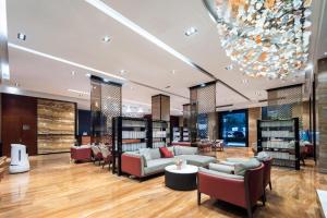 a lobby with a couch and chairs and a chandelier at Echeng Hotel Wuhan Optics Valley Square Yangjiawan Metro Station in Wuhan