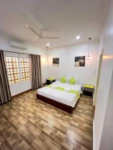a bedroom with a large bed with green pillows at Grand Apsara Residence in Siem Reap