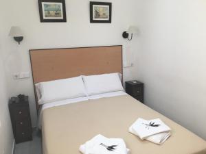 Un pat sau paturi într-o cameră la Hostal R. Lido