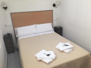 a bedroom with a bed with two towels on it at Hostal R. Lido in Madrid