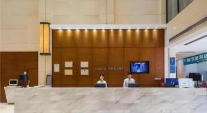 dwoje ludzi siedzących w holu z laptopami w obiekcie City Comfort Inn Dongguan Humen Wanda High-speed Railway Station Beizha w mieście Dongguan