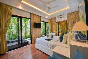 a bedroom with a large bed and a television at Amara Villa Umalas Bali in Canggu