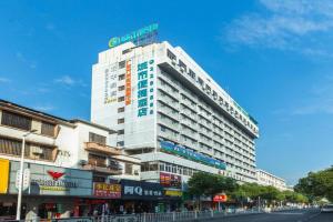 a tall white building with a sign on top of it at City Comfort Inn Zhaoqing Qixingyan Scenic Area Xinghu Archway in Zhaoqing