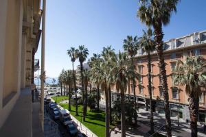 Blick auf eine Straße mit Palmen und ein Gebäude in der Unterkunft Albergo Malibu in Sanremo
