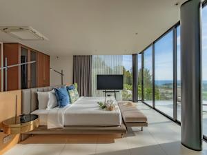 a bedroom with a large bed and a tv at NEW Luxury 4BR Villa in Layan - Villa Zuma in Layan Beach