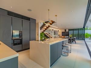 an open kitchen with a large island with bar stools at NEW Luxury 4BR Villa in Layan - Villa Zuma in Layan Beach