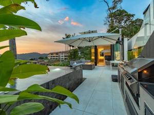an outdoor patio with an umbrella and a table at NEW Luxury 4BR Villa in Layan - Villa Zuma in Layan Beach