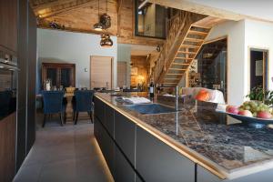 a kitchen with a counter with a sink and a living room at La Grange Neuve - OVO Network in Saint-Jean-d'Aulps