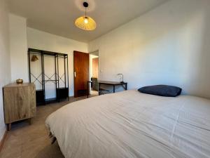 a bedroom with a large bed and a desk at Le Cosy Cévenol - Jardin et terrasse in Alès