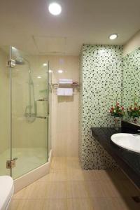 a bathroom with a glass shower and a sink at CWD Hotel in Hanoi