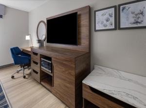 a bedroom with a tv and a desk with a bed at Hampton Inn & Suites Richmond Glenside in Richmond