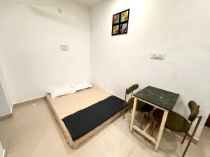 a small room with a bed and a table at Vibes stay in 5 in Hyderabad