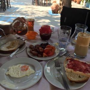 uma mesa com pratos de comida e bebidas ao pequeno-almoço em Pension Balos em Koumeika