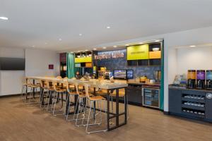 a restaurant with a bar with chairs and a counter at Home2 Suites by Hilton Milwaukee Brookfield in Waukesha
