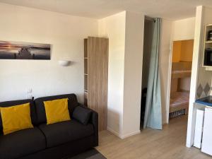 a living room with a black couch and a bedroom at Appartement 4 Personnes entièrement rénové en oct 25 Domaine de Valescure in Saint-Raphaël
