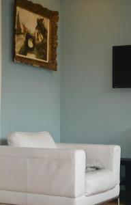een woonkamer met een witte bank en een schilderij bij Maison D'ide in Bouillon