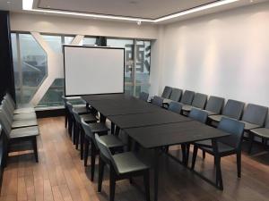 a conference room with a table and chairs and a screen at Xana Hotelle XiAn Gig Wild Goose Pagoda Branch in Xi'an