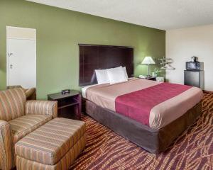 a hotel room with a bed and a chair at Econo Lodge Inn & Suites San Antonio near Frost Bank Center in San Antonio