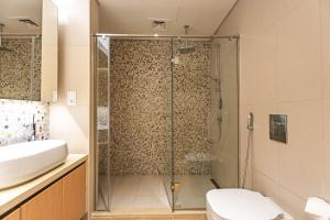 a bathroom with a shower and a toilet and a sink at Luxury 2BR Golf View 85" TV Yas Bay in Abu Dhabi +55 photos